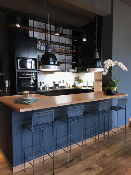 Cocina industrial moderna con isla de madera y luces colgantes — proyecto MONTAÑESES, por Estudio Cést Moi, en Núñez