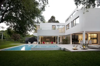 Moderna casa blanca con piscina y grandes ventanales — proyecto Carrara, por Remy Arquitectos