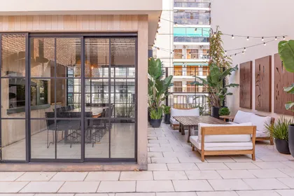 Patio moderno con deck de madera, pérgola y amplios ventanales — proyecto Terraza en la ciudad, por Casa Cunia, en CABA