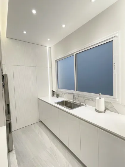 Cocina blanca minimalista con mesada de mármol y ventanal — proyecto Remodelación Cocina, por Estudio Nicolás Pierry