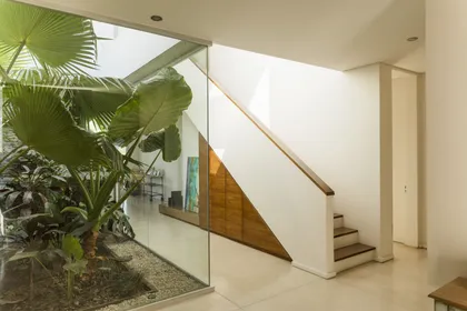 Escalera moderna con doble altura y jardin vertical en pasillo luminoso — proyecto Santa Barbara 121, por Build a Home Arquitectura, en B1648 Tigre