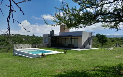 villa moderna con fachada de piedra y piscina — proyecto Complejo de Cabañas en Potrero de Garay, Córdoba, por ESTUDIO ARQ.GABRIEL ARIAS, en Córdoba