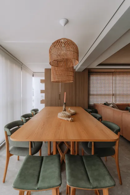 Comedor moderno con sillas verdes y lámparas de mimbre sobre mesa de madera — proyecto APTO C I P 32, por ARCAM ARQUITETURA , en São Paulo