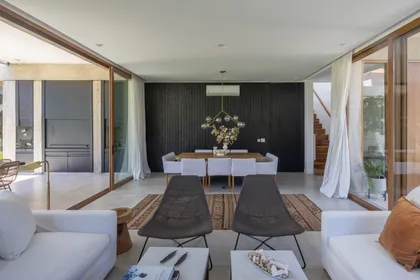 Living moderno con pared de madera negra y mucha luz — proyecto CASA OrAz, por Alfredo Orfila arquitectura, en San Isidro