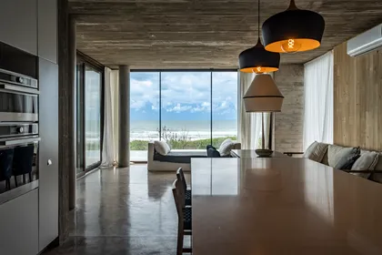 Living moderno brutalista con vista al mar y hormigón expuesto — proyecto CASA sobre el MAR, por Guerrero Arquitectos, en Pinamar
