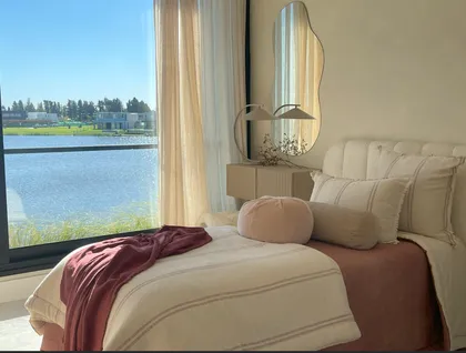 Dormitorio luminoso con vista al lago y espejo orgánico — proyecto El Secreto, por Grupo Pauta Arquitectura, en Tigre