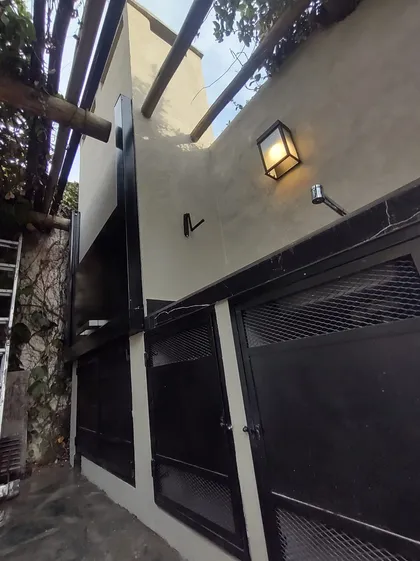 Fachada moderna con pérgola de madera y luces exteriores — proyecto Don Bosco , por MC Deco , en San Isidro