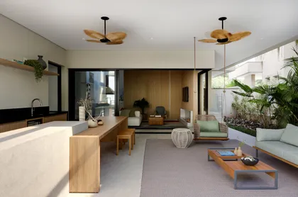 Amplio living comedor con cocina integrada, muebles de madera clara y ventiladores colgantes — proyecto Projeto Destaque Club&Casa, por Barbara Dundes – Arquitetura + Design