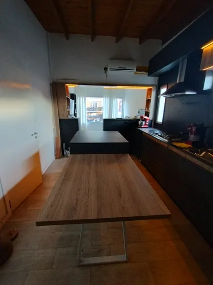 Cocina-comedor moderno rústico con vigas de madera y mesa larga — proyecto Diseño personalizado a gusto del cliente , por Saavedra Amoblamientos , en Pinamar