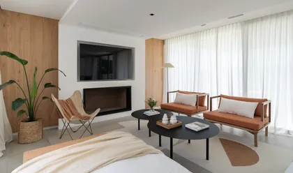 Living moderno con pared de madera, chimenea y muebles confortables — proyecto PROYECTO VISTAS, por July Acosta Home, en Belén de Escobar