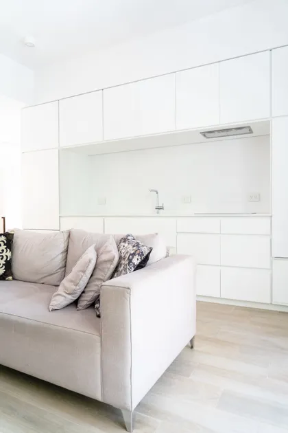 Living moderno con cocina integrada y muebles blancos minimalistas — proyecto Obra Laprida N, por Arq. Lourdes Yarade Saravia, en Buenos Aires