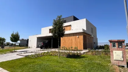 Fachada moderna de casa con concreto blanco y madera — proyecto Casa Puentes, por Guerrero Arquitectos, en Rincón de Milberg