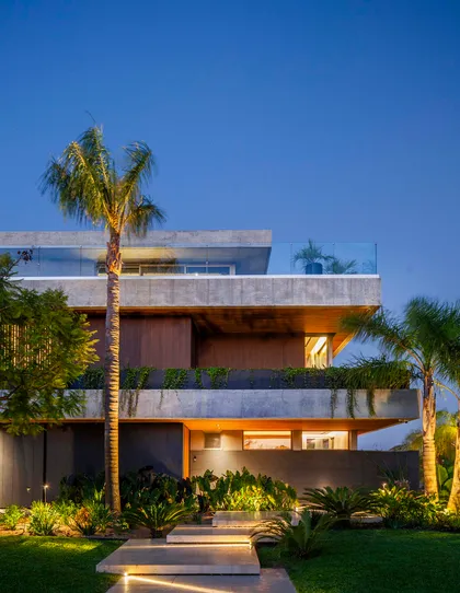 Fachada de casa moderna de concreto expuesto con vegetación tropical — proyecto Water House, por Remy Arquitectos, en Rincón de Milberg