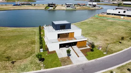 Casa moderna con fachada geométrica y grandes ventanales — proyecto Casa Puentes, por Guerrero Arquitectos, en Rincón de Milberg