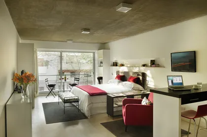 Monoambiente moderno con cama y living integrados, techo de cemento — proyecto Ravignani Studios, por Mazzinghi Sanchez, en Palermo