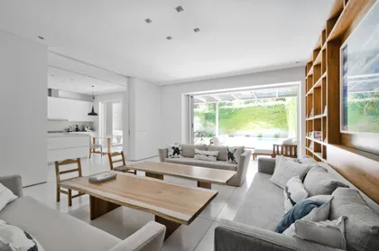 Sala de estar moderna con ventanales y muebles de madera natural — proyecto Casa D, por Estudio Dado, en Belgrano
