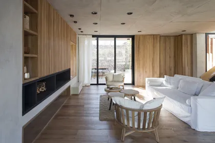 Living moderno con paredes de madera y ventanal grande — proyecto Casa Carol, por Estudio Lak, en Club Newman