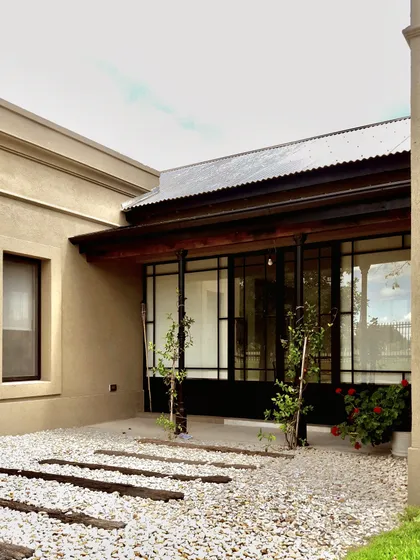 Patio moderno con grava blanca, pasos de madera y pérgola de chapa — proyecto Los Jazmines Pilar del Este, por Marconi Silva Arquitectos, en Pilar del Este