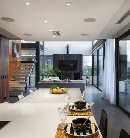 Living moderno y luminoso con escalera flotante y chimenea — proyecto Casa BJM, por Vanguarda Arquitectos, en Belén de Escobar