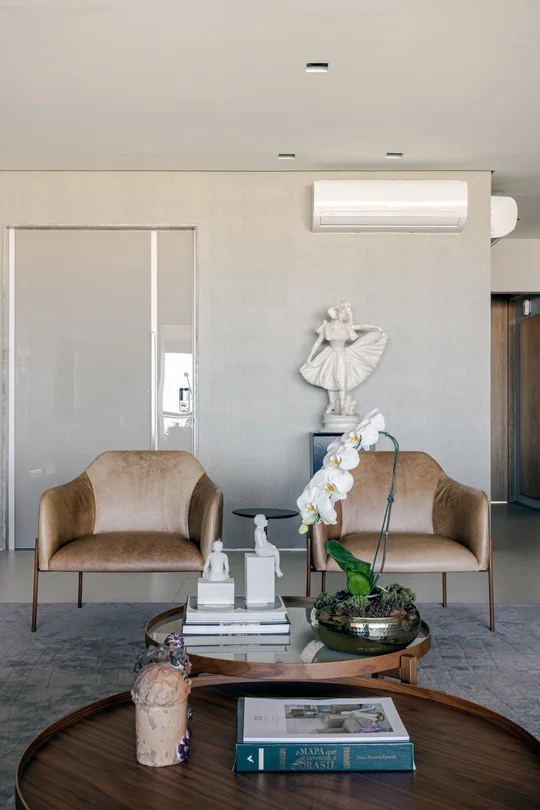 Living minimalista con dos sillones beige y mesas bajas de madera — proyecto Apto M | E, por Arquitetura Paulo Melo E Paulo