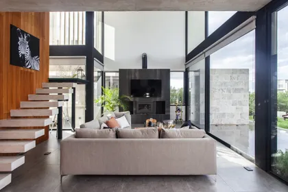 Living moderno con doble altura y escalera flotante — proyecto Casa BJM, por Vanguarda Arquitectos, en Belén de Escobar
