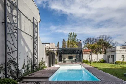 Piscina moderna con deck de madera y estructura metálica — proyecto Casa PMorán, por Vanguarda Arquitectos, en CABA