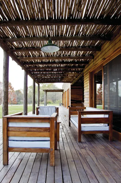 Terraza rústica con pérgola de madera natural y mobiliario sencillo — proyecto Chacra Pilará, por Mazzinghi Sanchez, en Pilará
