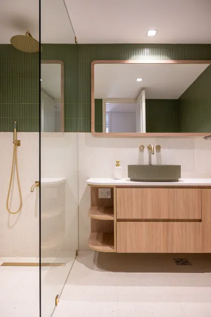Baño moderno con bacha verde, grifería dorada y mueble de madera — proyecto ALVEAR TYM, por AB ARQUITECTURA, en Recoleta