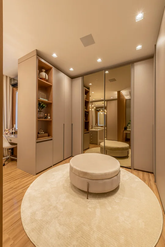 Vestidor contemporáneo con espejo de cuerpo completo y puf central beige — proyecto Projeto Destaque Club&Casa, por Andrea Carvalho Arquitetura