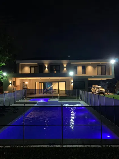 Casa moderna con piscina iluminada de noche — proyecto Casa Roy, por Arcucci Arquitectura, en Pilar