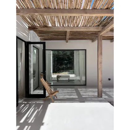 Espacio exterior rústico con pérgola de madera y silla de madera — proyecto CE, por arquitectura.JD, en Pinamar