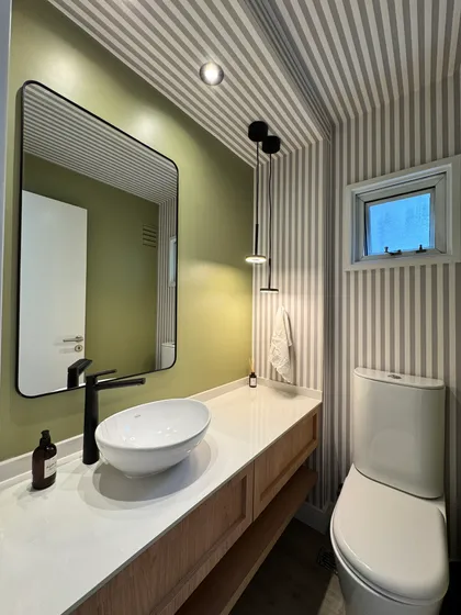 Baño moderno con lavabo sobre encimera, grifería negra y papel rayado — proyecto Lafinur, por MDBK Arquitectura, en Palermo