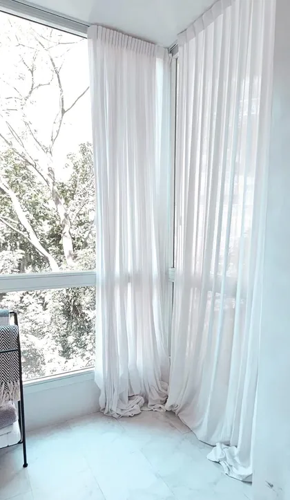 Balcón con cortinas blancas y vista a vegetación — proyecto Billinghurst, por Claraboia , en Palermo