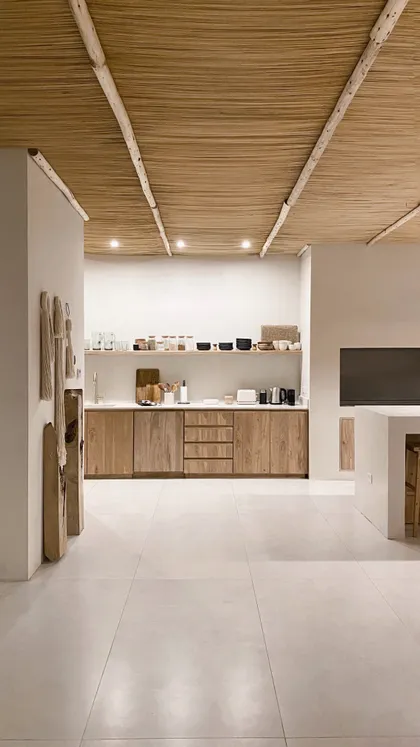 Cocina minimalista estilo boho rústico con techo de paja y vigas de madera — proyecto El Refugio, por Grupo Pauta Arquitectura, en Pinamar