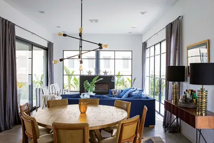 Living comedor moderno con sofá azul, chimenea y mucha luz — proyecto Casa Las Liebres, por Mazzinghi Sanchez, en Garin