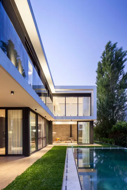 Casa moderna con piscina y amplias vistas, iluminación indirecta y jardín — proyecto CASA WINDBELLS, por ABAD GADANO, en Tigre