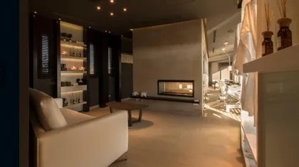 Living moderno con chimenea minimalista y sillón de tela beige — proyecto Spa Ville St Germain, por Estudio de Int Diana Gradel, en Cariló