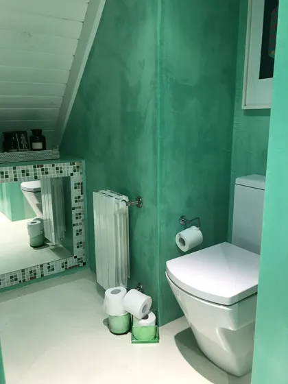 Baño moderno con paredes de microcemento verde y techo de madera blanca — proyecto Monroe - La Horqueta, por Mgc.arq, en La Horqueta