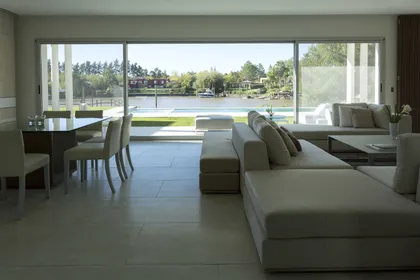 Living comedor moderno con vista al exterior y ventanales amplios — proyecto Residencia Tigre, por LIVE IN by Brukman Chechik, en Tigre