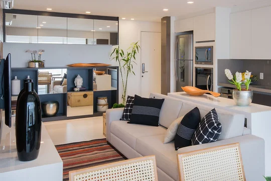 Living moderno integrado con cocina, sofá gris y detalles en madera natural — proyecto Studio Pinheiros, por Bordin E Soares Interiores
