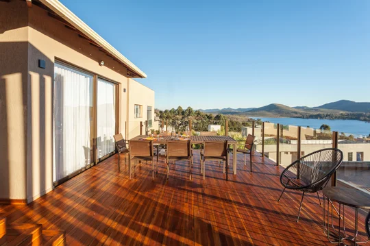 Terraza con deck de madera, vista panorámica a lago y montañas — proyecto CASA RR, por Frederico Bicalho Arquitetura