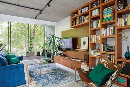 Living moderno con ventanales, estanterías altas y conexión interior-exterior — proyecto Interiorismo Núñez , por Arq.solange Mauri, en Núñez