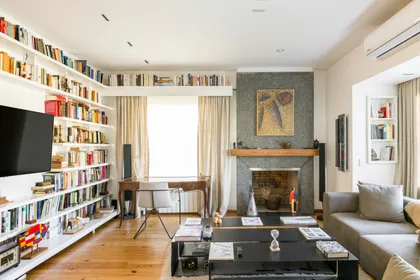 Living moderno con biblioteca infinita y hogar a leña — proyecto Boating Club, por SRMD Arquitectura, en Boating Club