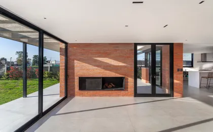 Living moderno con pared de ladrillo y chimenea — proyecto CASA BSB, por BUSCETTI & DI BERNARDO arquitectas, en Gonnet
