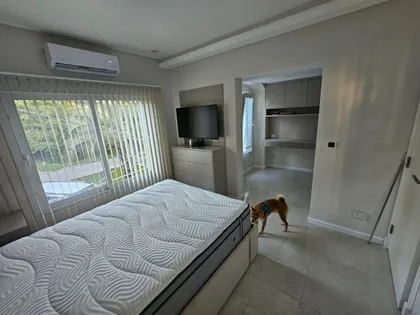 Dormitorio moderno con gran ventana y perro — proyecto Reforma V, por de Sautu Di Matteo arquitectos , en Canning