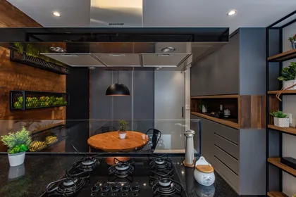 Cocina moderna con isla redonda, estufa negra y detalles en madera — proyecto Duo Morumbi, por Pricila Dalzochio