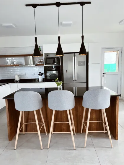 Cocina moderna con isla, barra y luces colgantes — proyecto Haras Santa Maria, por Estudio RG, en Belén de Escobar