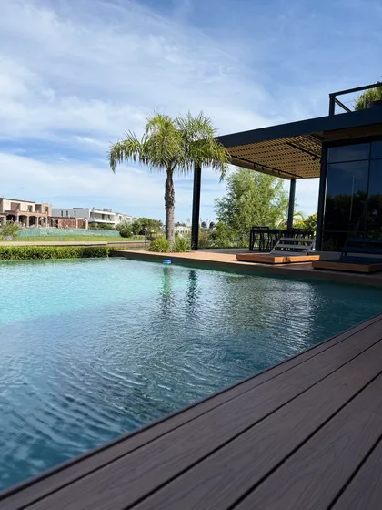 Piscina moderna con deck de madera y palmera — proyecto ALBANUEVA, por Baires Green, en B1648 Tigre