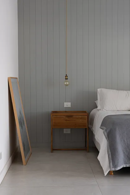 Habitación minimalista con pared de listones grises y cama sencilla — proyecto Casa Al Agua - Grupo PAUTA, por Gaby Alfonso, en Belén de Escobar
