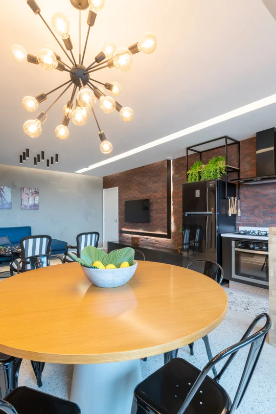 Comedor moderno con mesa redonda amarilla y lámpara araña dorada — proyecto Brick 1, por Pricila Dalzochio